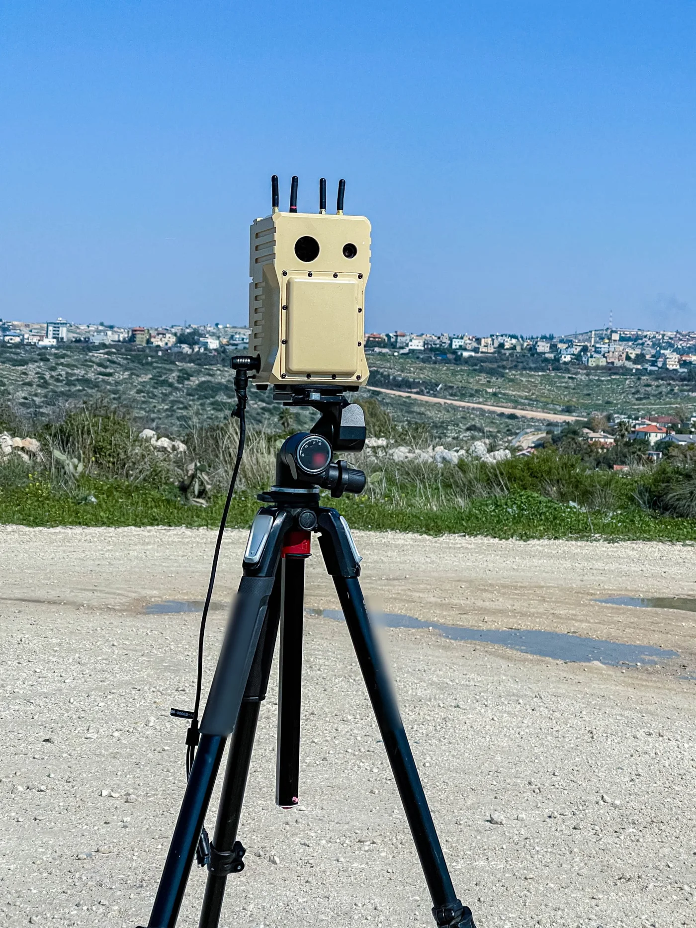 FIREFLY multi-sensor unit with antennas on a tripod overlooking open terrain