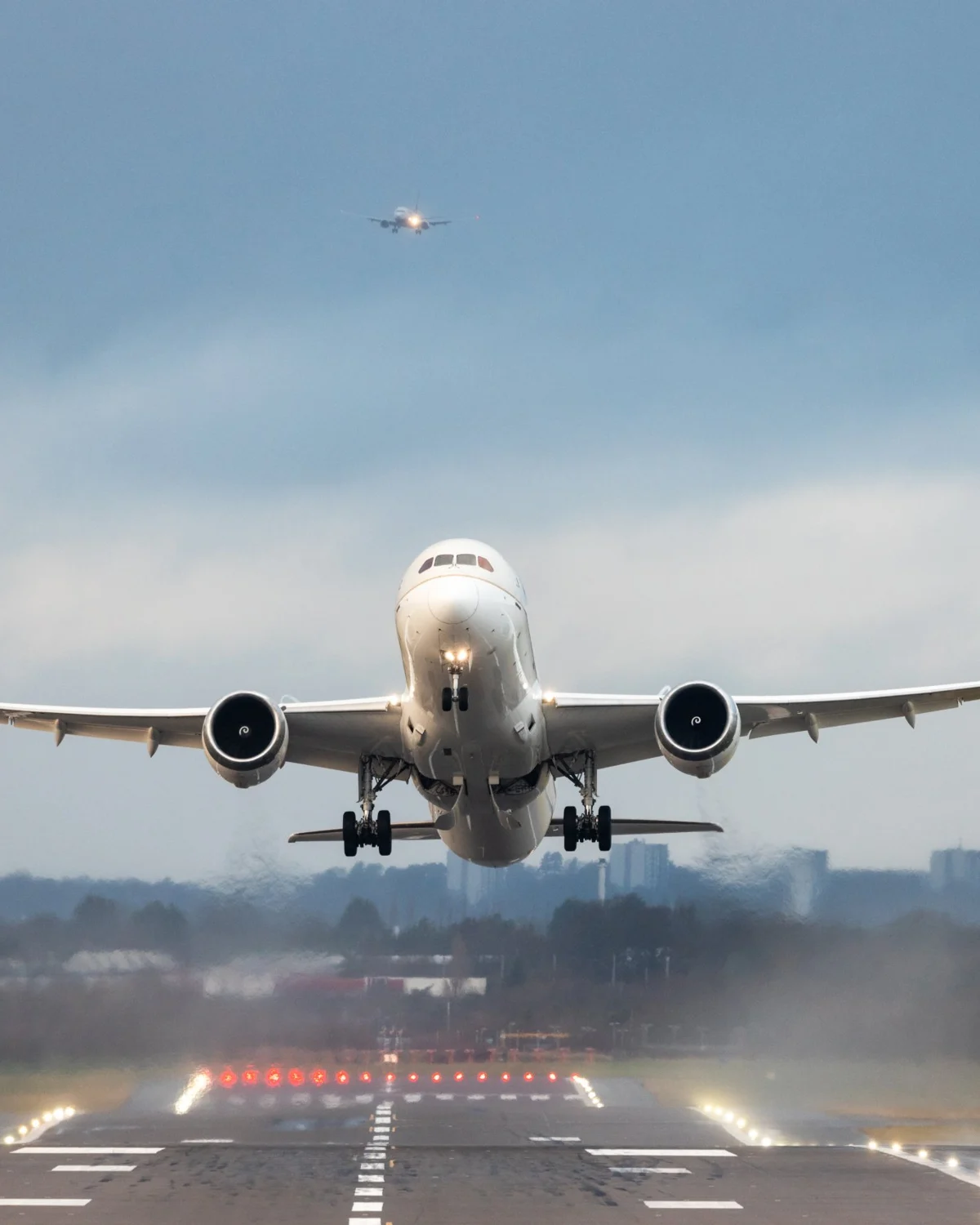 Passenger aircraft taking off from a runway with another aircraft on approach