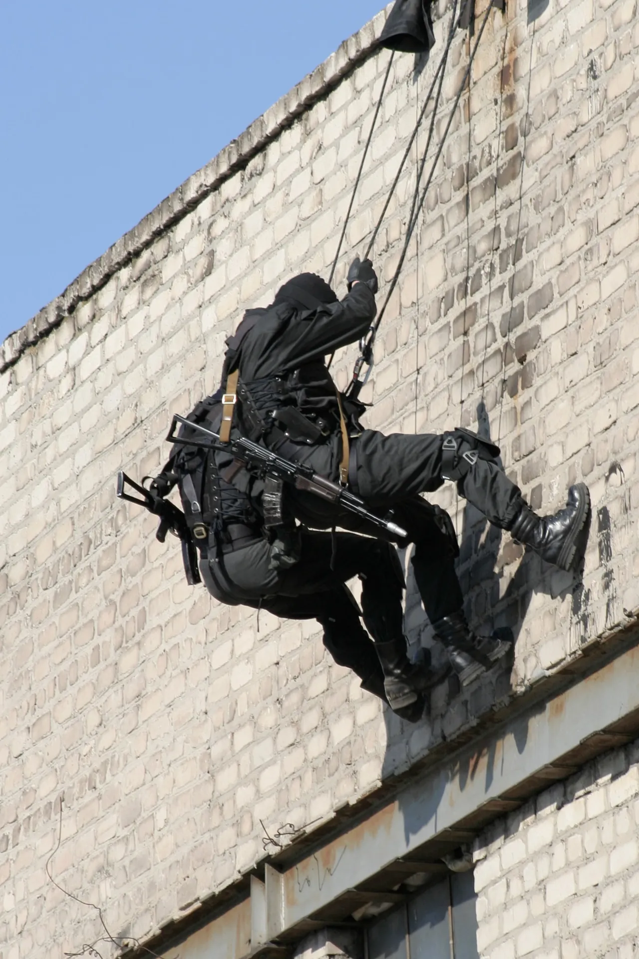 Special forces operator abseiling down a building wall